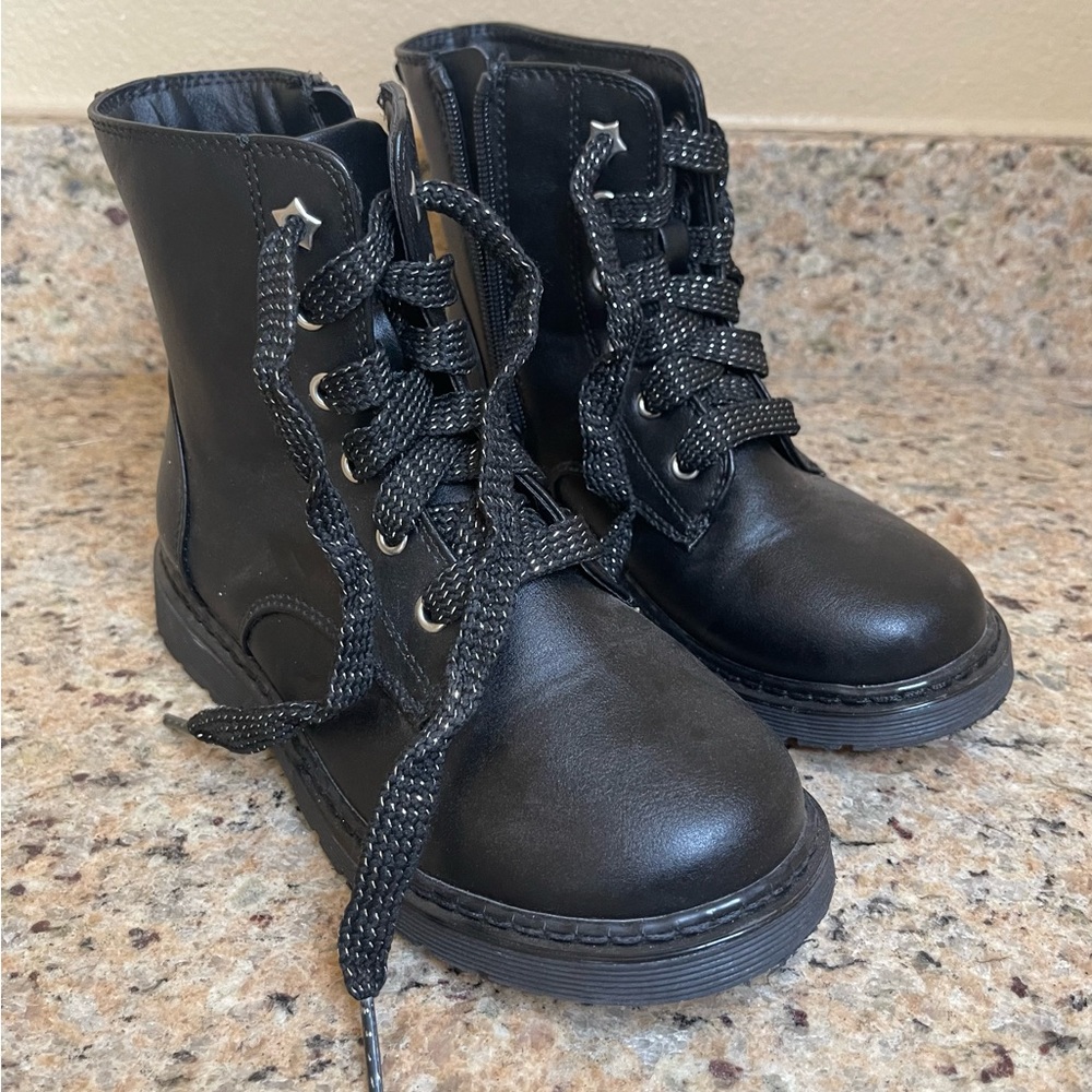 Girls lace up black combat boots.